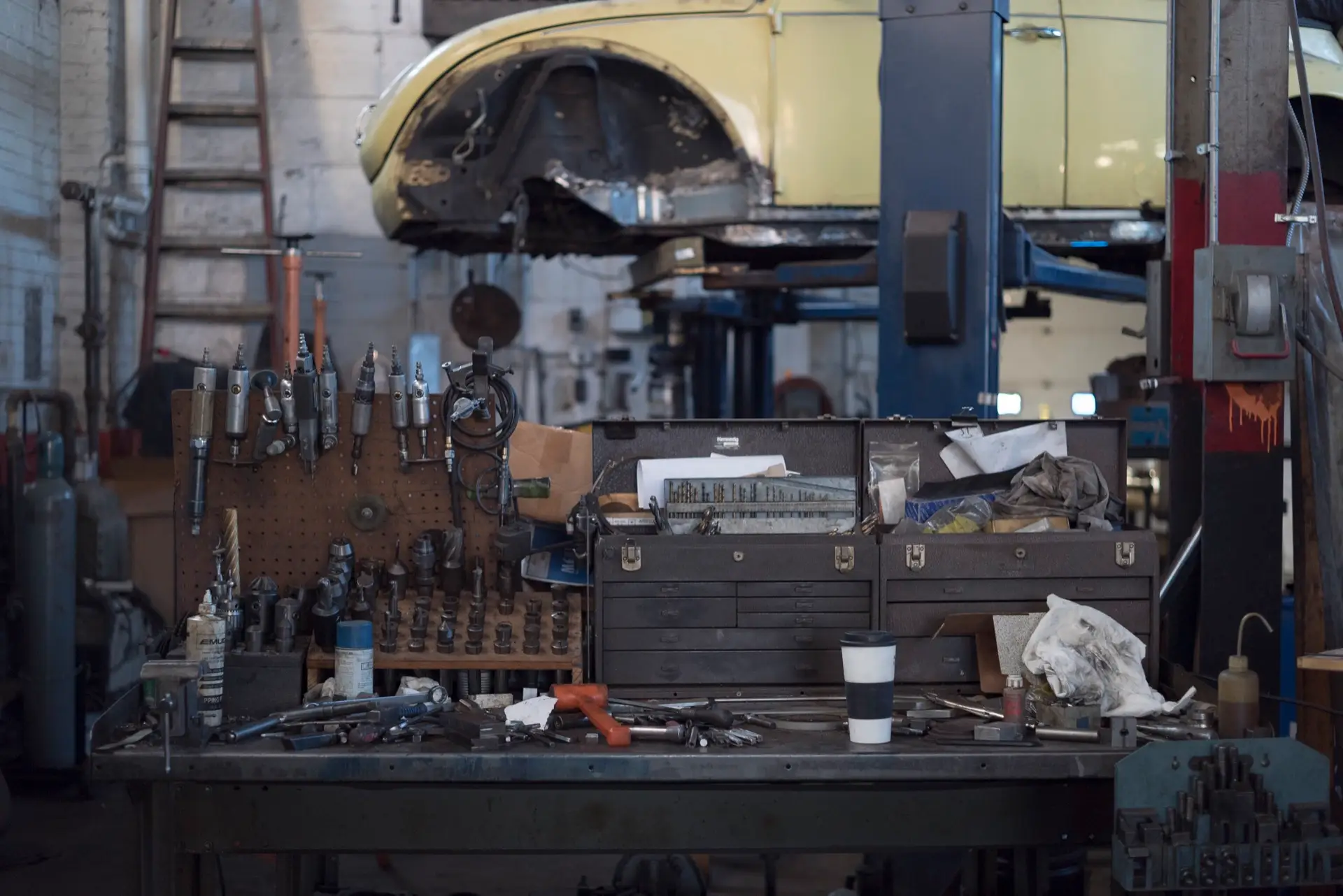 Mechanic's workbench and tools in front of a car raised on a lift, Park Crescent Garage Worthing