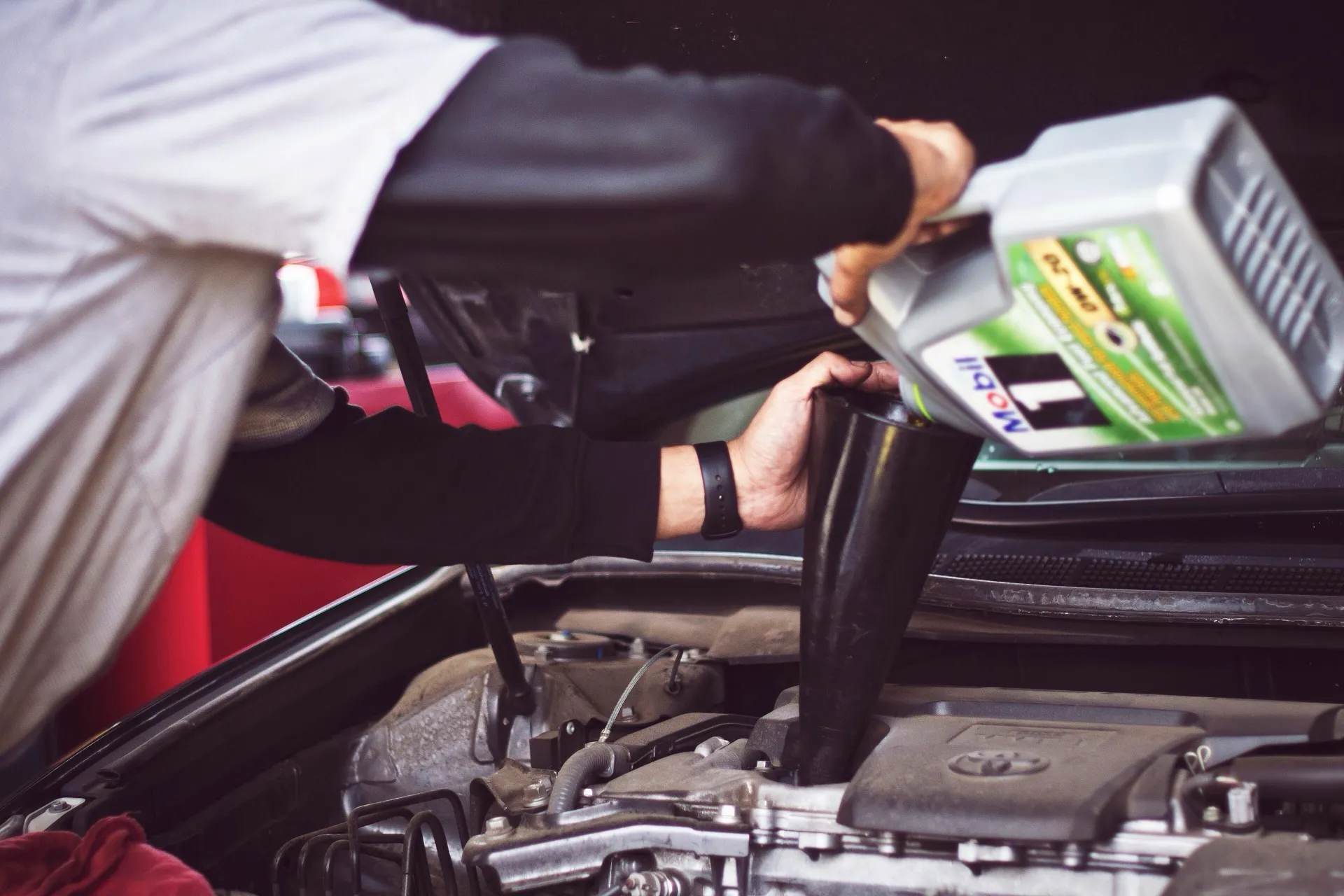 Mechanic pouring fresh engine oil during a car service at Park Crescent Garage Worthing